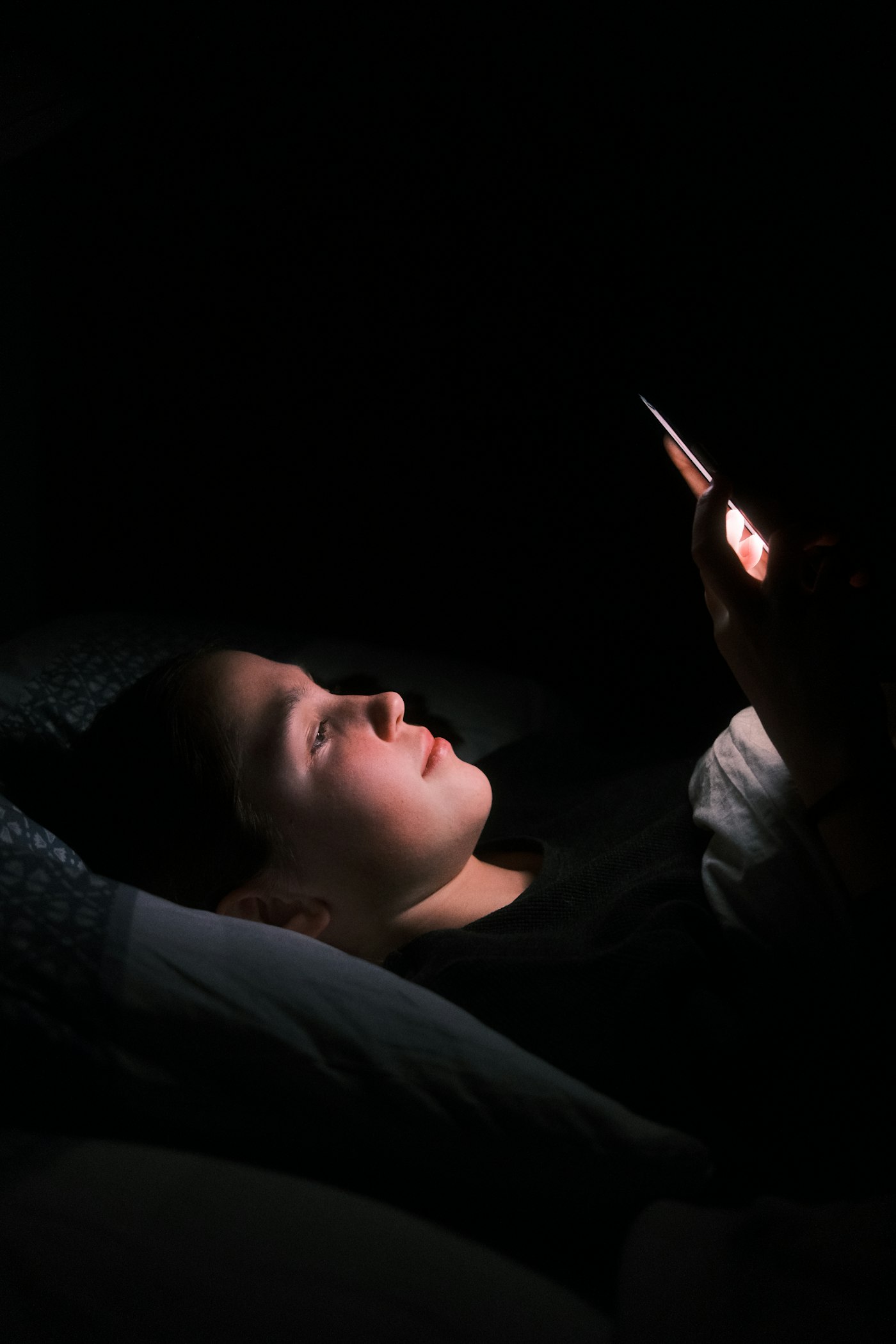Una persona escribiendo en su teléfono de noche
